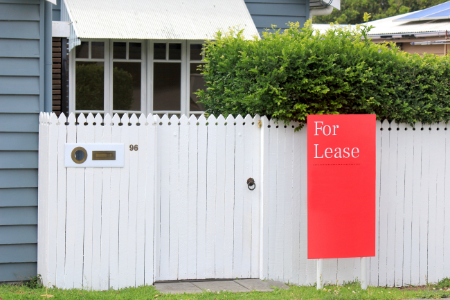 home with white fencing around it and a red sign that says "for lease" example of property eligible for 1031 exchange