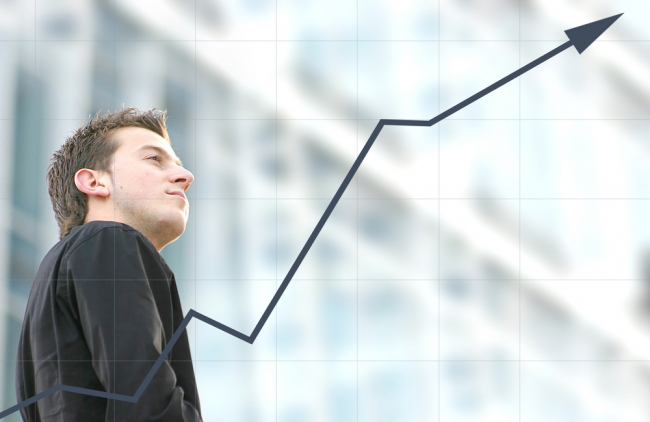 confident business man in front of a graph gradually increasing