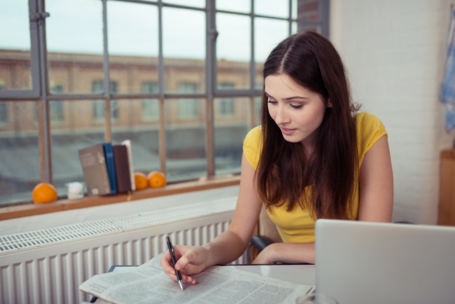 Woman Marking Ads for Real Estate in Newspaper